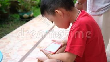 亚洲男孩专心看智能手机